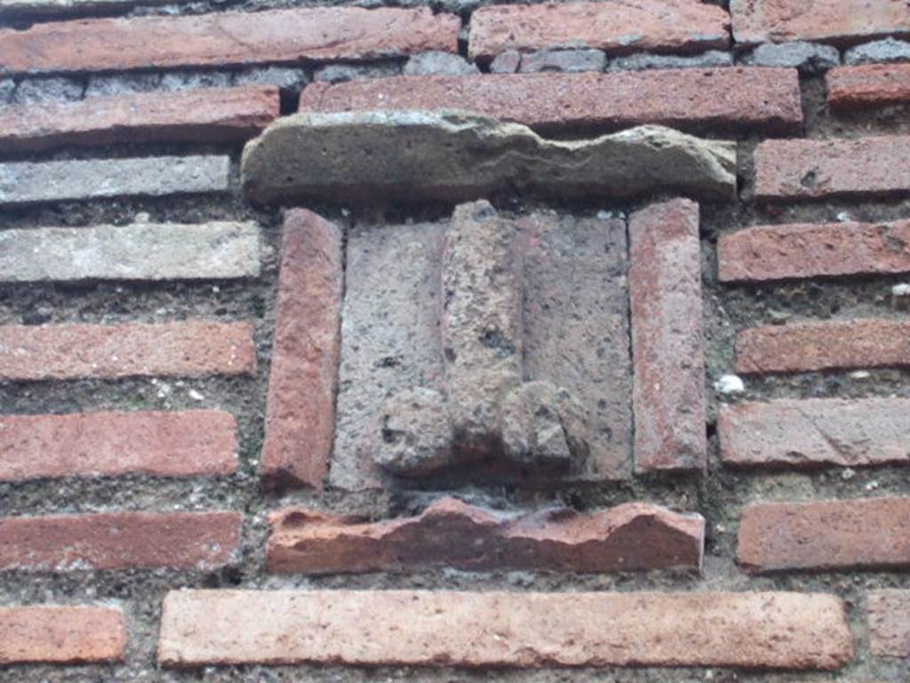 Plaque between IX.1.13 and IX.1.14.  December 2005. According to Gallo, the sign on the fa�ade showing a tufa phallus was the only merit of this shop.
The plaque, originally painted azure blue, shows an erect phallus with appendices painted in red, with an inscription painted in red below:
Ubi me iuvat, asido  (CIL IV, 950)
According to Varone, this translates at �When it suits me, I sit on it�
(Asido is written instead of assido)
See Varone, A., 2002. Erotica Pompeiana: Love Inscriptions on the Walls of Pompeii, Rome: L�erma di Bretschneider. (p.90) 
See Gallo, A: L�insula I della Regione IX, Settore Occidentale, in Studi della Soprintendenza archeologica di Pompei, no. I, 2001, (p.53)
