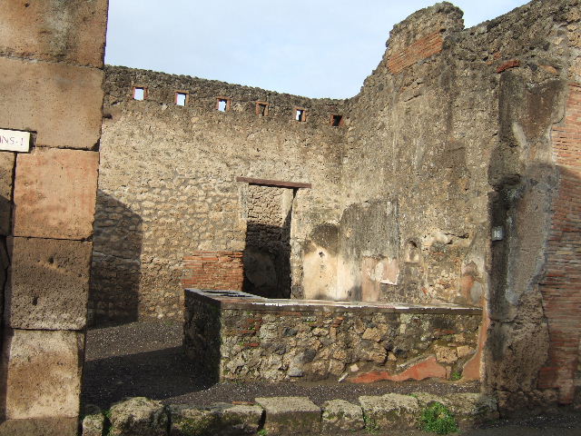 IX.1.16 Pompeii. December 2007.  Pillar on corner of crossroads of Via Stabiana and Via dell’ Abbondanza, with remains of red painted Oscan inscription.  

