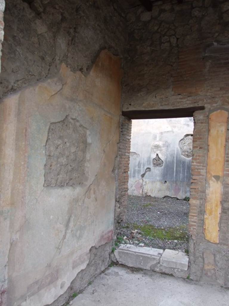 IX.1.22 Pompeii. December 2007. Room 7, tablinum, west wall and doorway with one step to room 10 in north-west corner.
According to BdI, in the middle of the side walls, on a blue background, were two paintings.
The one that was found on the right (east wall) was almost entirely destroyed, only a fragment of a group of cupid and Pan was preserved. The painting on the left (west) wall represented Hermaphrodite and Silenus. See BdI, 1867, (p.48)
According to Bragantini, the painting of Hermaphrodite and Silenus was found on the east wall.
See Bragantini, de Vos, Badoni, 1986. Pitture e Pavimenti di Pompei, Parte 3. Rome: ICCD. (p.401, tablinum ‘h’)