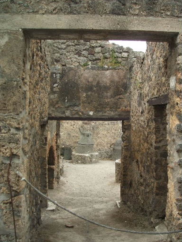 IX.1.33 Pompeii. May 2005.  Looking west from hole in brickwork of IX.1.32, along the south side of the oven in IX.1.33. IX.1.3 is seen in the background.


