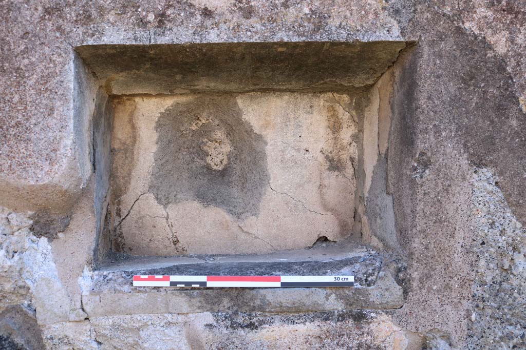 IX.2.7 Pompeii. December 2018. Detail of niche in south wall of shop room. Photo courtesy of Aude Durand.
According to Boyce –
In the south wall is a rectangular niche (h.0.32, w.0.44, d.0.22, h. above floor 1.45).
The excavation report stated this was a lararium. He gave the reference Bull. Arch. Nap., N.S.1, 1853, 25.
See Boyce G. K., 1937. Corpus of the Lararia of Pompeii. Rome: MAAR 14. (p. 80, no. 392).