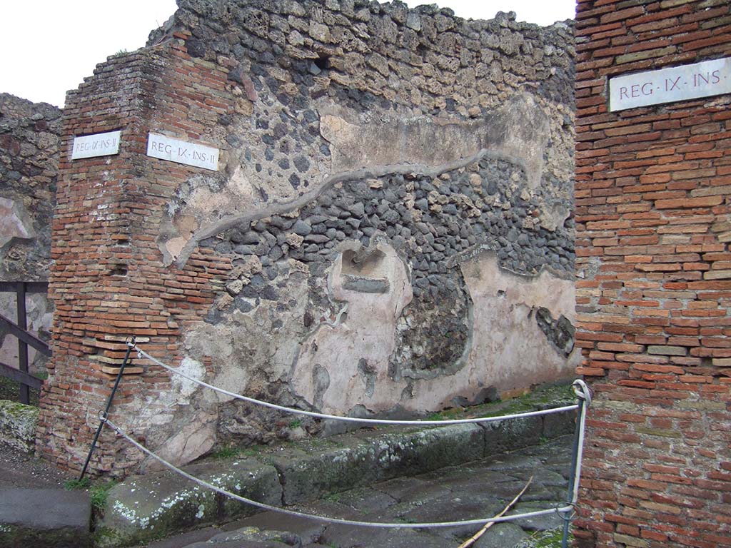 Street altar on SW side of IX.2.12 on Vicolo di Balbo, looking east from Via Stabiana. December 2005.
According to Fiorelli, at this point was a painting of two large serpents approaching a niche hollowed out of the wall.
Underneath was the effigy of the altar among luxurious plants.
Above the painting and continuing on the same wall, there remained various electoral programmes.
See Pappalardo, U., 2001. La Descrizione di Pompei per Giuseppe Fiorelli (1875). Napoli: Massa Editore. (p. 142)
See Fr�hlich, T., 1991. Lararien und Fassadenbilder in den Vesuvst�dten. Mainz: von Zabern. (F61)
See Helbig, W., 1868. Wandgem�lde der vom Vesuv versch�tteten St�dte Campaniens. Leipzig: Breitkopf und H�rtel. (29)
