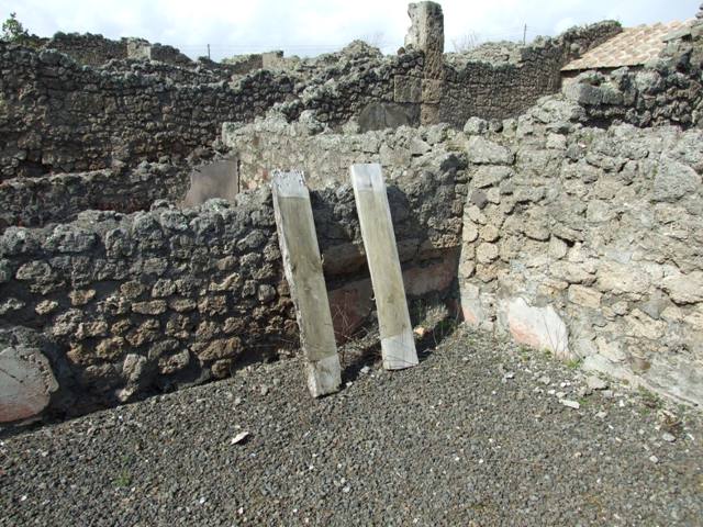 IX.2.17 Pompeii. March 2009. Room 9, garden area. Looking north-west towards north side and columns at the west end. According to Boyce, the two columns at the west end of the north row were connected by a low wall. On the south side of this wall, facing the open area, was painted in red a simple aedicula with pediment. Within the aedicula were painted two yellow serpents confronted at an altar.
See Boyce G. K., 1937. Corpus of the Lararia of Pompeii. Rome: MAAR 14. (p. 81, no. 397)