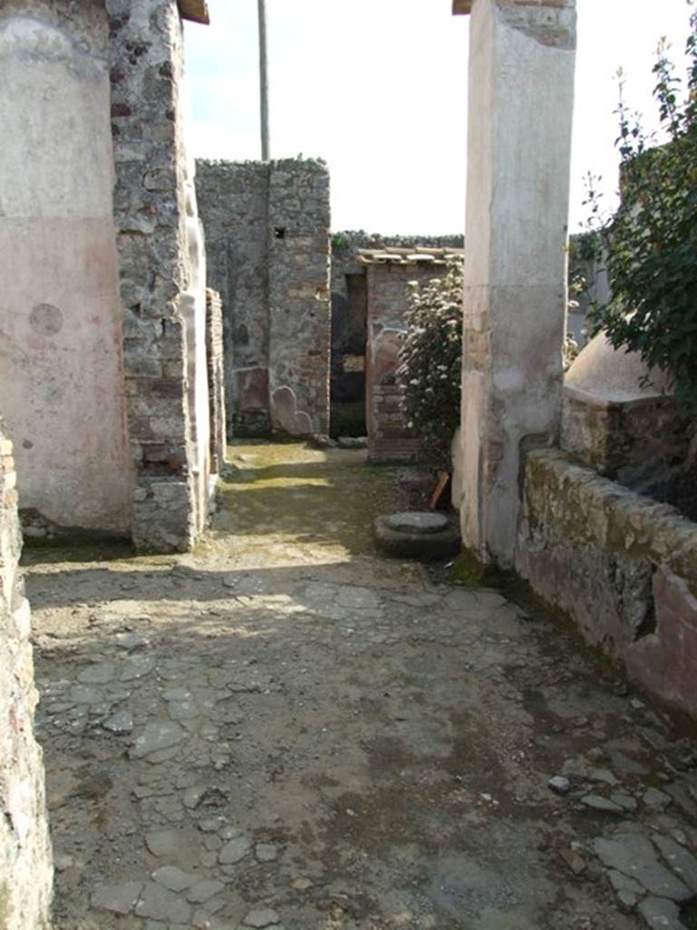 IX.3.5 Pompeii. March 2009. Room 21, corridor, looking south. Large doorway to room 20, on left. According to Dyer: “The peristyle is surrounded on two of its sides with square columns, painted with plants on a red background. The pillars are connected together by a low wall, which leaves two openings into the xystus, or garden. On the other sides it is bounded by the tablinum in front, and by an exedra or oecus, on the right (of the peristyle)”.
See Dyer, T., 1867. The Ruins of Pompeii. London: Bell and Daldy. (p.85)
