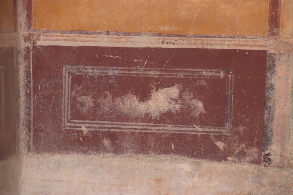 IX.3.5 Pompeii. October 2023.
Room 13, painted sea-monster and dolphin from predella on lower west wall, in south-west corner. Photo courtesy of Klaus Heese.