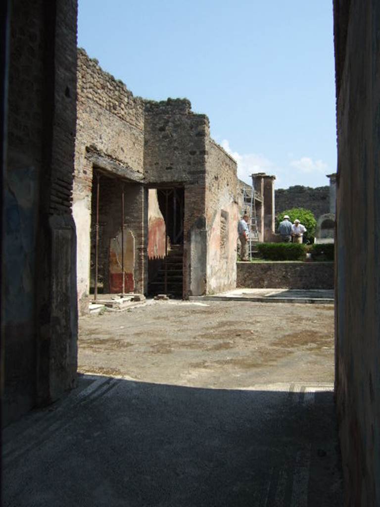 IX.3.5 Pompeii. May 2006. North-east corner of atrium. According to Dyer: “This house appeared to have been under repair at the time of the eruption; at least we cannot in any other way account for the rough state in which the impluvium or water-basin, in the atrium was found. It was no doubt intended to be lined with marble: in its present state it forms a strong contrast with the elegance of the rest of the atrium. This has a pavement of white mosaic; the lower part of the walls are painted in imitation of variously-coloured marbles; above, the walls are blue and ornamented with grotesques; the whole surmounted by a frieze of gilt stucco, many fragments of which were found during the excavation. The bed-chambers and other rooms which surround the atrium contained several good paintings, some of which have been removed to Naples Museum.
See Dyer, T., 1867. The Ruins of Pompeii. London: Bell and Daldy. (p.84)