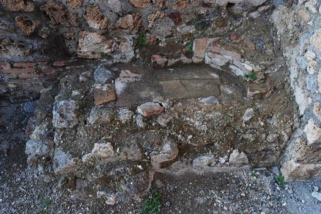 IX.3.10 Pompeii. May 2003. Detail of masonry remains on north side of doorway linking shop to bakery, possibly a small hearth. Photo courtesy of Nicolas Monteix.
