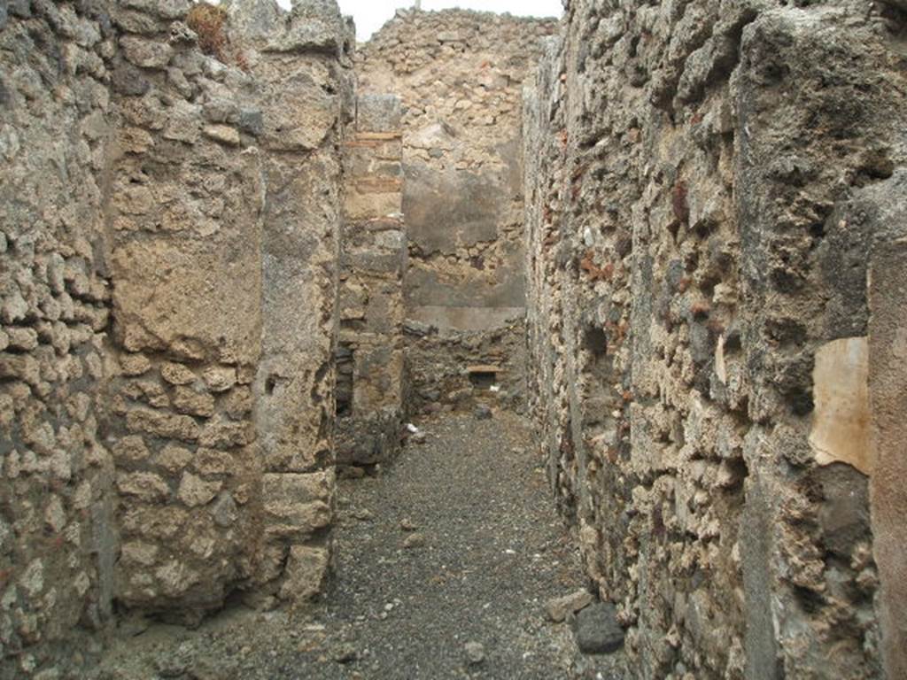 IX.3.14 Pompeii. May 2005.
Corridor to rear on west side, which was only partly covered by a roof, containing the fusorium, hearth and the latrine.