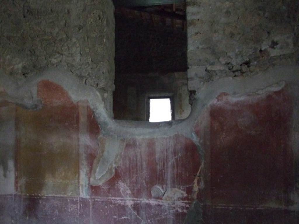 IX.3.19 Pompeii. December 2007. Room 12, north wall of triclinium, with window into oecus.
The making of the window interrupted the symmetrical structure of the IV style decoration on this wall. This wall had a violet/purple zoccolo which was divided into panels and narrow compartments, which continued up onto the middle zone, painted with candelabra. In the middle of the wall was a red aedicula with a central painting, but only traces of the lower framework was still visible. The side panels were yellow, and at their extremity were black panels, but now totally faded and appearing white. In each of these side panels, was a medallion, also now faded, but the outline could be seen.
See Carratelli, G. P., 1990-2003. Pompei: Pitture e Mosaici: Vol. IX. Roma: Istituto della enciclopedia italiana, (p.350)