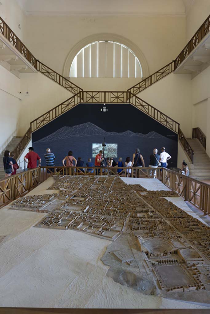 Cork model on display on Naples Archaeological Museum. July 2017.
Looking north from Gladiators Barracks and Theatres at VIII.7 on Via Stabiana, lower right.
Foto Annette Haug, ERC Grant 681269 DÉCOR.
This model in the Naples Archaeological Museum, made of wood, cork and paper, by Felice Padiglione, is scaled at 1/100, and shows the excavations up until the end of 1879.
Many models of the city were produced, including one on display in an exhibition in VIII.2.14/16 in 2018.
That model featured the houses on the western side of VIII.2, that is VIII.2.1/3 the Houses of Championnet, VIII.2.14/16, VIII.2.17/21 the Sarno Baths, and the next few properties on the southern slope.
According to the Archaeological Park of Pompeii display notice in VIII.2.14/16 -
“The cork model was begun in 1865 by Giovanni Padiglione, one of several models predating the great model of the entire city now in Naples Archaeological Museum.
It was created over the course of several stages, following the advance of archaeological discoveries, as demonstrated by the Courtyard of the Moray Eels, excavated at the end of the nineteenth century, and the lower floors of the houses which were investigated in the 1930’s.
In addition, the wall and floor decorations, painted on paper, do not correspond with those that were originally present; most probably it was decided to substitute them with those of a more profound impact from other houses, for educational purposes.”