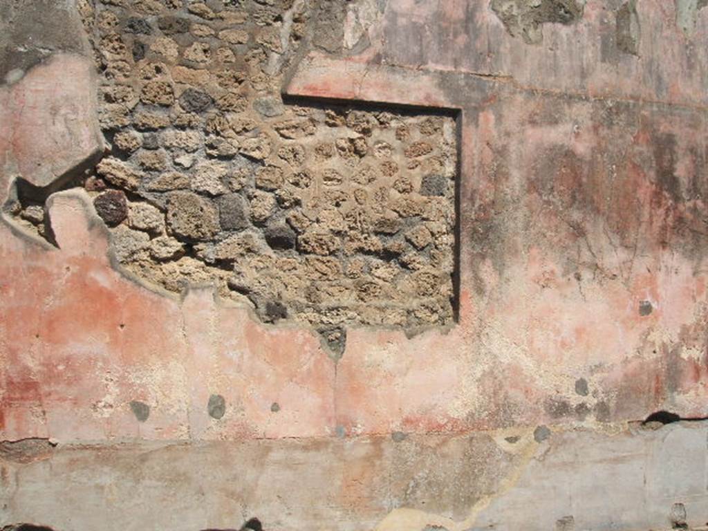 IX.5.14 Pompeii. May 2005. Room �f�, north wall of triclinium with painting cut from it.
In the black zoccolo were panels with squares alternating with narrow compartments with painted plants: 
Seen in the side panels of the red middle zone of the wall, were vignettes with painted Muses, (but badly preserved). 
In the centre would have been a painting with a scene of uncertain identification, possibly Dido receiving Aeneas for the first time.
