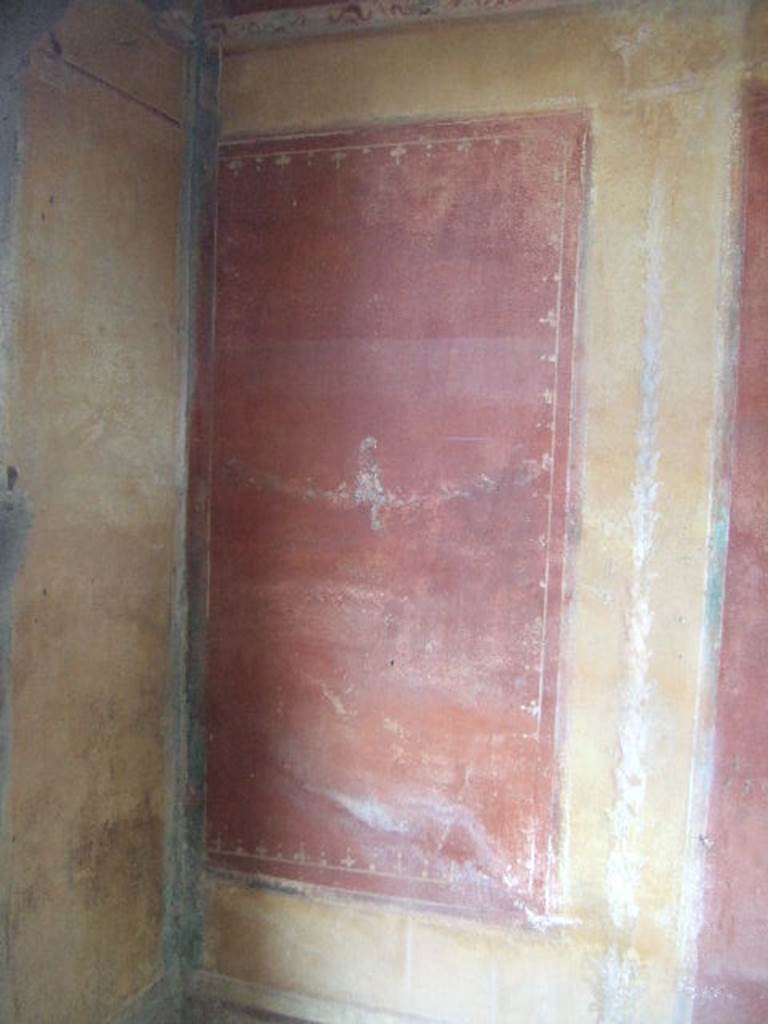 IX.5.14 Pompeii. May 2005. Cubiculum �g�, on south side of entrance doorway.
Painted red panel with a bird on a garland in the centre of the west end of north wall.


