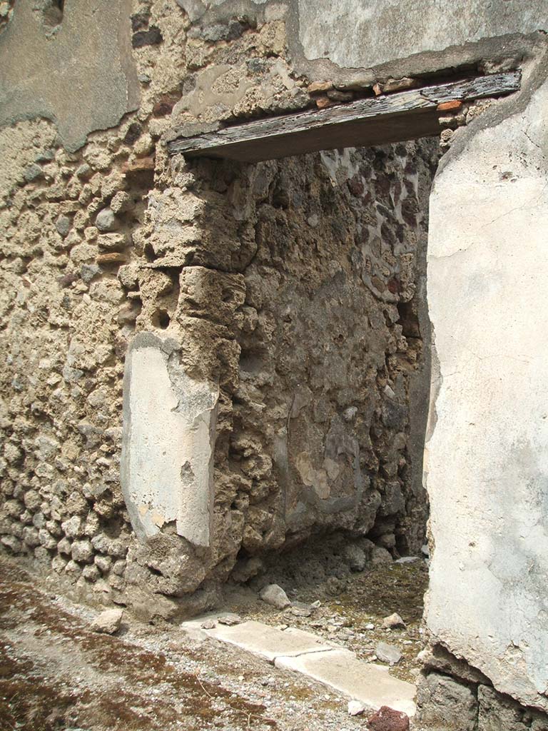 IX.5.17, Pompeii. May 2005. Entrance doorway. The exterior plastered zoccolo was painted black.
The door threshold was made from a slab of marble, with holes for the hinges.