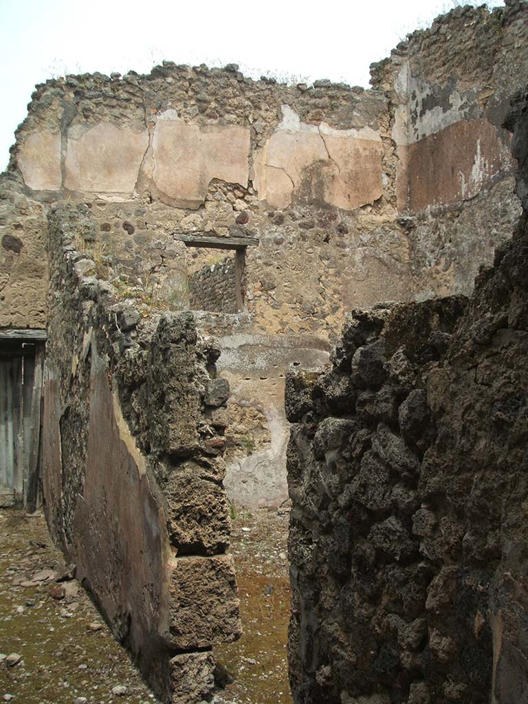 IX.5.17/6 Pompeii. May 2005. Looking north along corridor y to doorway to garden u.
Doorway to the stable q leading to room x is on the right.
The upper floor, above the stable, shows the remains of the zoccolo and of the white middle zone of the walls.