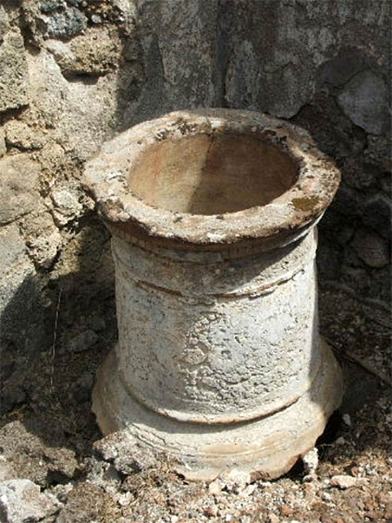 IX.6.3 Pompeii. May 2005. Terracotta puteal in kitchen area, “i”.
According to Mau, in the corner to the left of the entrance doorway was the mouth of the cistern with terracotta puteal.
Back in time this had been roughly refaced with white stucco.
In a nearby corner was a low basin (0.74 x 0.98, 0,18 deep).
The hearth, in the south-east corner, was of an irregular shape.
Nearby on the left wall was the usual lararium painting.
See Mau in BdI, 1880, (p.220).