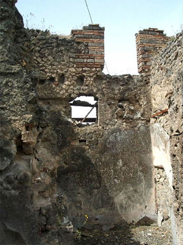 IX.6.3 Pompeii. May 2005.
Room “m” to south of entrance corridor, with window in west wall onto Vicolo di Tesmo.
According to Mau, room "m" had a wooden threshold, the jambs of the entrance were furnished with door-frames.
The floor, a type of opus signinum, was decorated with stars and in the centre, with a square-shaped ornament, simple but with good effect, all made from white stones.
The plaster of the walls showed a rough decoration with a white background in the IV style:
Originally in the centre of each wall had been a flying cupid;
• the one on the right carried a thyrsus and crown,
• that to the rear a thyrsus and a helmet on its left,
• the one on the left carried a shepherd’s crook and an unrecognizable object.
In the south-west, a narrow doorway gave passage to room "L".
The threshold was exceedingly high and had the appearance of having been the first step of a staircase, which maybe first gave access to the upper floor before the stairs were built in room "i".
See Mau in BdI, 1880, p.220-1.