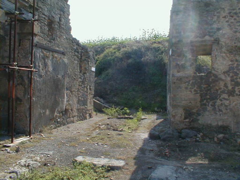 IX.8 Pompeii on left. End of Vicolo del Centenario, looking south (into the unexcavated). Corner of IX.6.8, on right.