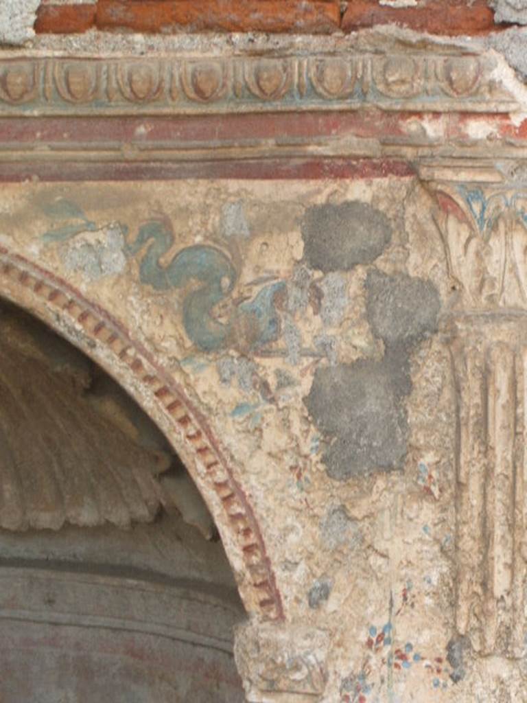 IX.6.8 Pompeii. May 2005. Detail from aedicula lararium of a sea-monster. Stucco and painted plaster on front external, upper north corner.