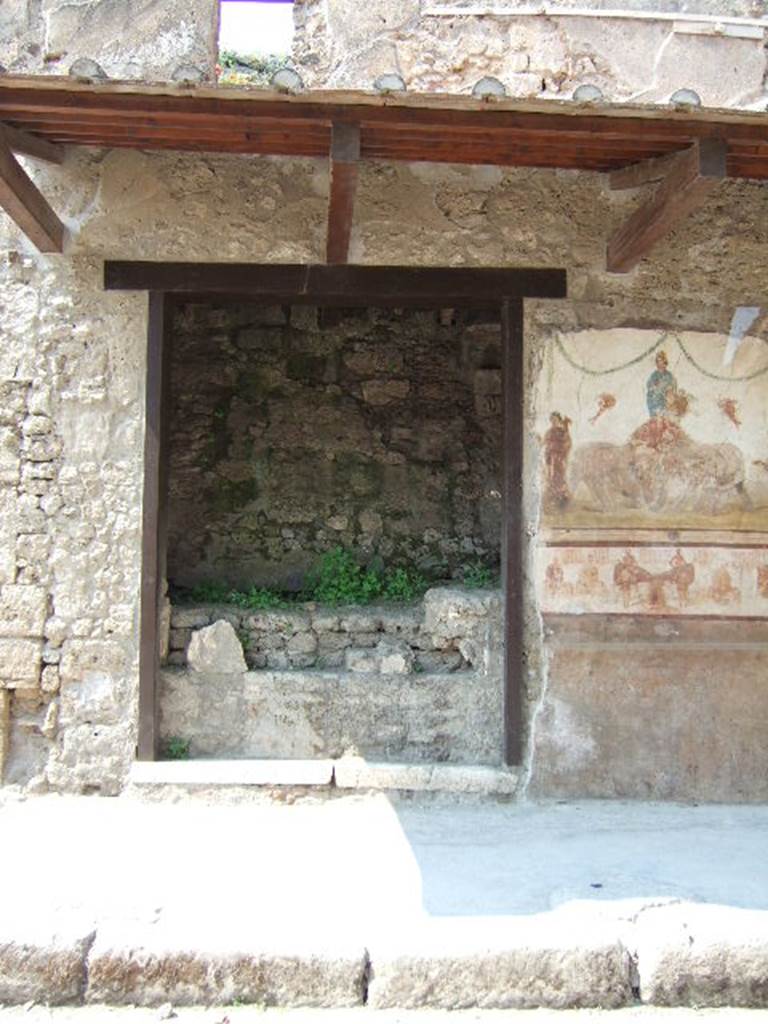 IX.7.7 Pompeii. May 2006. Entrance on Via dell’Abbondanza. Upon excavation, a plaster-cast of the door was made showing the horizontal long bolt made of iron. Part of this plaster-cast can still be seen in the doorway, although it has deteriorated with age.
On the left of the doorway was a painting of Mercury with inscriptions above, and another painting below. The paintings have now been detached from the wall and are held in the storerooms together with CIL IV 7841 and 7842. (inventory number 40685. Found on the lower painting, from the pilaster on the left of the doorway, were inscriptions CIL IV 7843 and 7844. These have now almost vanished.
See Varone, A. and Stefani, G., 2009. Titulorum Pictorum Pompeianorum, Rome: L’erma di Bretschneider, (p.407-411)