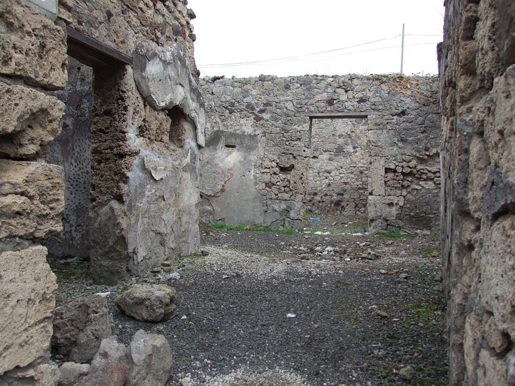 IX.7.19 Pompeii. December 2007. Looking east across room b, the atrium, with doorway to room a, cubiculum, on left.
Also visible behind the room a on the left, was an ala, room c.
This ala may have been used as the tablinum.
According to Mau, when excavated the following paintings were found on the walls of this room.
Room b, the atrium:
On the left wall between the doorway of room a, and room c, the ala – a peacock, in front of two pomegranate trees and a branch. (size: height 0.10m x length 0.33m)
On the right wall in front of the door to room e, buried into the plaster and fixed with four iron nails, was a slab of dark-blue glass not regular in shape, that one could have believed had served as a mirror. (size: height 0.22m x length 0.135m)
(According to NdS, 1880, p.491, “buried into the plaster was a slab of glass with a black background”).
See Mau, in Bullettino dell’Instituto di Corrispondenza Archeologica (DAIR), 1883, (p.79).
See Sogliano, in Notizie degli Scavi di Antichità, 1880, (p.491).