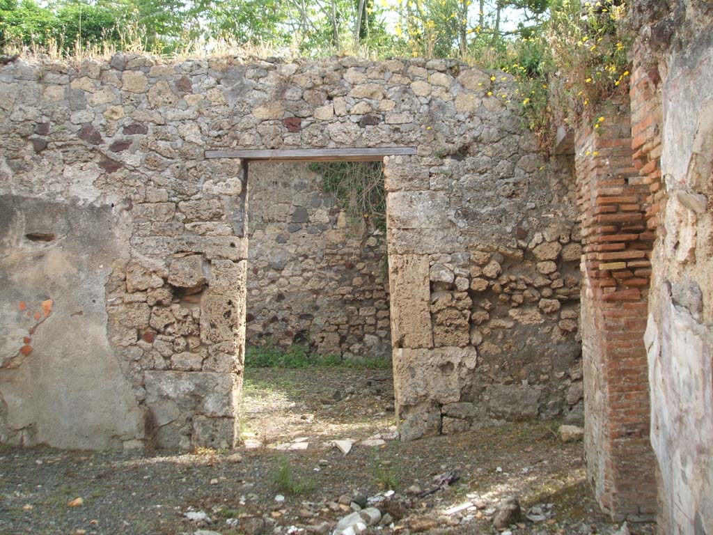 IX.7.19 Pompeii. May 2005. Looking east to doorway to room g, triclinium in rear wall of atrium, in centre of photo.
The threshold in the doorway of the triclinium was made of marble.