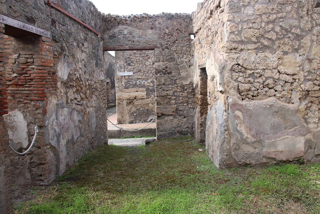 IX.7.19 Pompeii. October 2024. Looking west across atrium towards entrance doorway on Vicolo di Tesmo.
The doorway to room e, is on the left, in the south wall, and doorway to room a, and c, on the right, on north side. Photo courtesy of Klaus Heese.