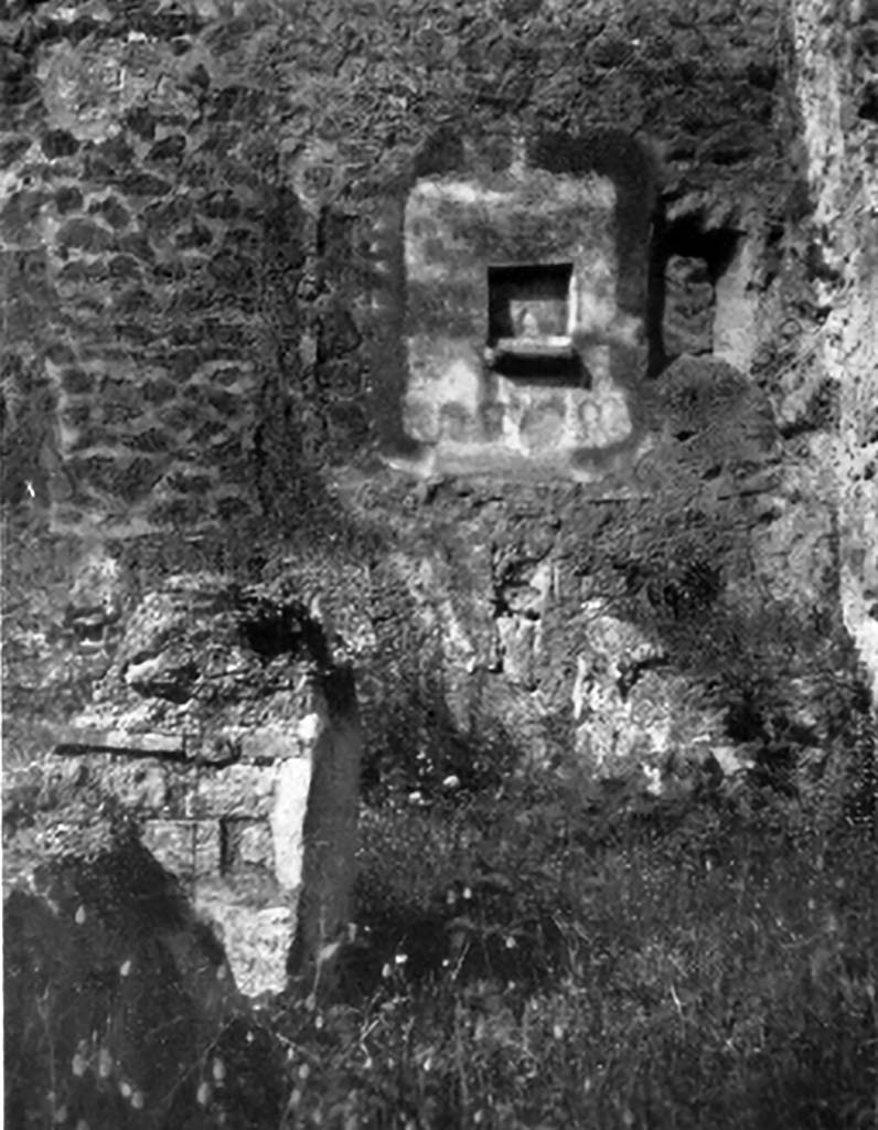IX.7.21 Pompeii.1930s photo by Tatiana Warscher of lararium niche and hearth.
According to Boyce, above the hearth in the west wall was a panel of white stucco. In the panel was a square niche.
Below the niche was a painted garland of red and green leaves and below it a burning altar with a pine-cone.
On either side of the altar was a yellow serpent.
The serpent on the left had a red crest and beard, the head of the other was damaged.
See Boyce G. K., 1937. Corpus of the Lararia of Pompeii. Rome: MAAR 14. (p.88, no.441, and Pl.4, 4)