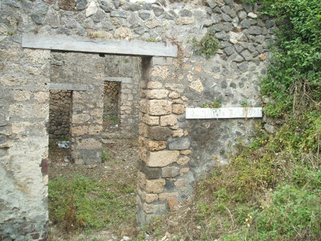 IX.9.g Pompeii. May 2005. Entrance doorway, looking east. According to NdS, this was the doorway to a modest house but had a painting advertising that this was the house of a �painter of electoral programmata�. The doorway led directly into the small atrium which had an attic above, as in the previous house (IX.9.f). The upstairs room had a balcony which jutted out into the roadway, but this had completely fallen when found.
See Notizie degli Scavi, 1891, p.264.
According to NdS, a graffito was found written in charcoal, on the inner surface of the right doorjamb. The doorjamb was faced with yellow painted plaster imitating coloured marble. The graffito showed  -
��� XV| K AVG
XXX XXXV
LXX XV K AVG XL
LXX LX
LXX LX
LXX LX
L.. LX F
LXXX XIIII K aVG LX
LXXXX LX
�.. xL xxxC � xLx
According to Sogliano, a drawing found on the right doorjamb showed a male figure in black outline (0.16 high). This was drawn almost from behind his shoulders, stretching his right hand forward, as if in the act of signing something on the wall, and was perceived certainly to be Aemilius Celer, shown in the act of painting slogans on the house-walls of Pompeii. Underneath in black letters, nearly vanished, was the wording - aemiliVS CELER.
See Notizie degli Scavi, 1888, p.520 (recorded as being from IX.7, near the seventh doorway in the side street)
