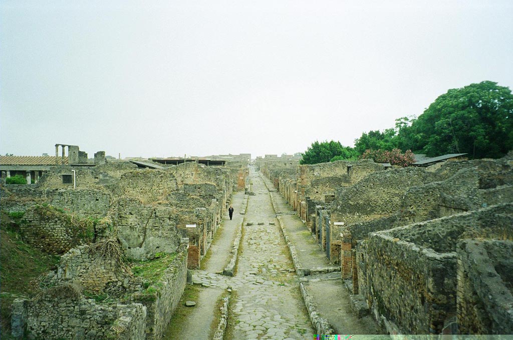 IX.10.1 Pompeii. May 2010.
Entrance fauces 1, cubiculum 3 and bred making room 4 and oven 7a are partly visible on the left of the Via di Nola. Photo courtesy of Rick Bauer.