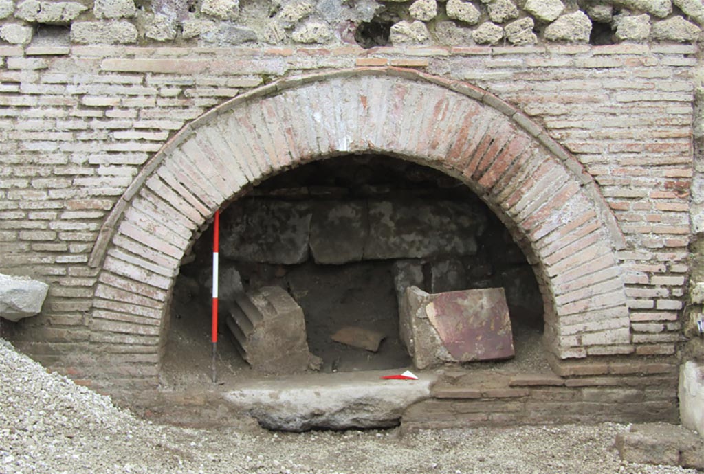 IX.10.1 Pompeii. December 2023. Oven 7a. Looking west to the oven front.
The partially visible structures already suggested the presence of a production facility with an oven, a hypothesis that was confirmed when the burying material was removed.
Along the north wall of oven 7a, a rectangular basin (ca. 1.50 x 0.80 m) was uncovered, the bottom of which has not yet been reached.
A significant feature of room 7 is the presence of two circular masonry structures, not entirely visible at present, on which the circular cones of two millstones must originally have rested, cones that are, however, not present on the bases. The condition of the excavation, which is still in progress, leads one to be cautious; however, it is legitimate to ask whether the absence of the millstones is attributable to removals that occurred during the 19th-century excavations.
IX.10.1 Pompei. Maggio 2023. Forno 7a. Vista verso ovest sul fronte del forno.
Le strutture parzialmente a vista facevano già supporre la presenza di un impianto produttivo con forno, ipotesi che ha trovato conferma allorché si è proceduto alla rimozione dell’interro.
Lungo la parete nord del vano 7a si è messa in luce una vasca rettangolare (1.50 x 0.80 m ca.) di cui ancora non si è raggiunto il fondo.
Elemento significativo di ambiente 7 è la presenza di due strutture circolari in muratura, attualmente non del tutto visibili, su cui, in origine, dovevano poggiare le mete circolari di due macine, mete che però non sono presenti sulle basi. La condizione dello scavo ancora in fieri induce ad essere cauti, ad ogni modo è lecito domandarsi se la mancanza delle macine sia imputabile ad asportazioni avvenute durante gli scavi ottocenteschi.
Photograph © Parco Archeologico di Pompei.
Vedi/See Ri-scavare Pompei: nuovi dati interdisciplinari dagli ambienti indagate a fine ‘800 di Regio IX, 10.1.4. E-journal 2, Scavi di Pompeii, 29.5.2023, p. 4, fig. 3. E-journal on PAP web site