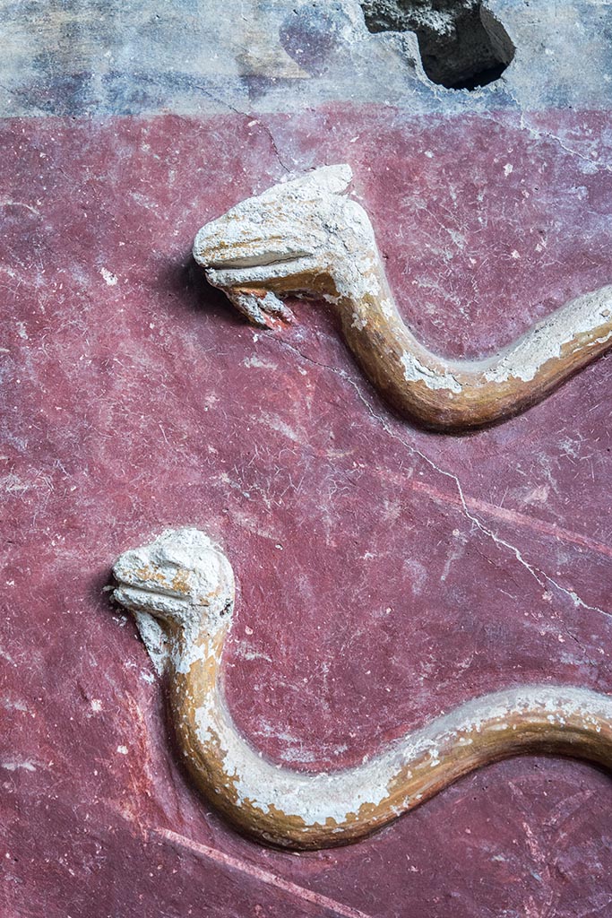 IX.10.1, Pompeii. July 2024.
Room 12, detail of stucco serpents from centre of upper south wall. Photo courtesy of Johannes Eber.
