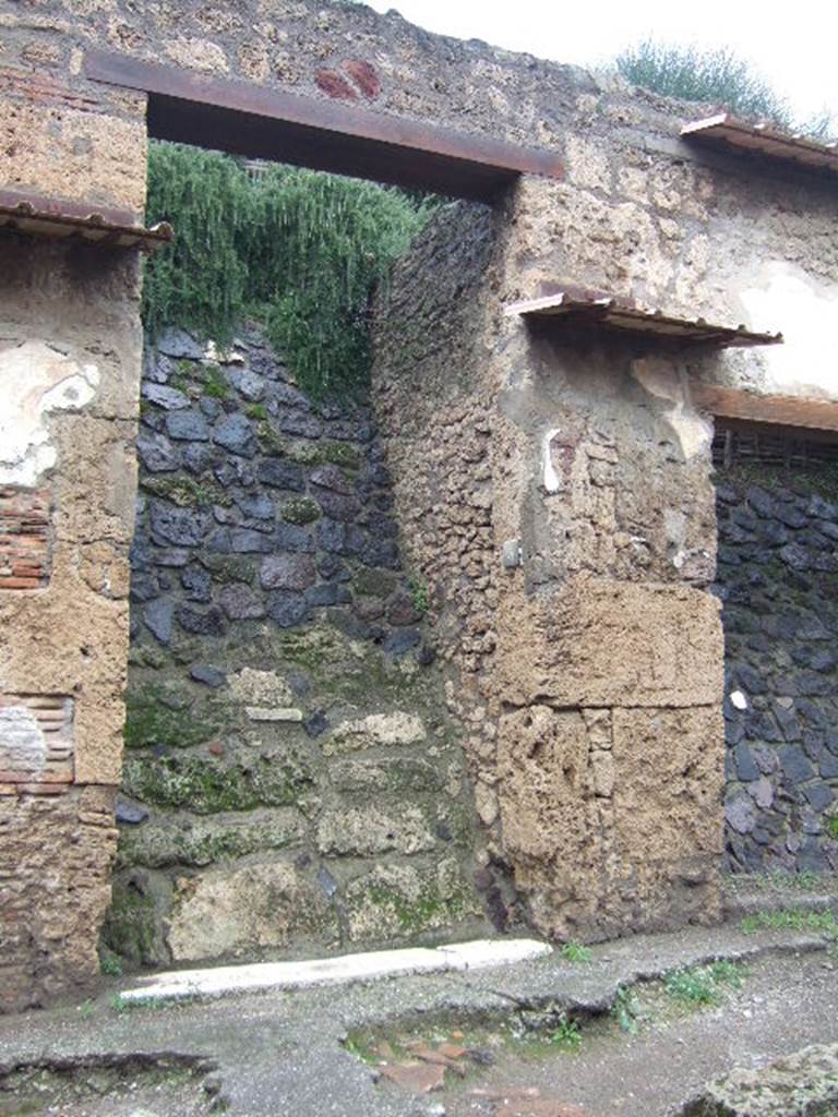 IX.13.5 Pompeii.December 2005. Entrance doorway. There was a small painting on either side of the doorway. These were surrounded by the chessboard decoration still visible at IX.13.6. Aeneas was on the right hand side of the door and Romulus on the left. See Fröhlich, T., 1991, Lararien und Fassadenbilder in den Vesuvstädten. Mainz: von Zabern. (F72, p.339/40).