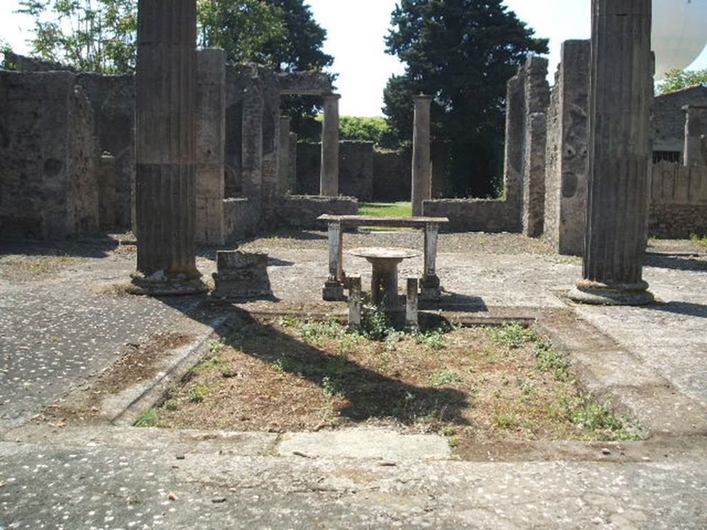 IX.14.4 Pompeii. May 2005. Looking south across impluvium in atrium B towards tablinum H. When discovered, the walls of the tablinum where covered with rough plaster, awaiting their coating of fine decoration. Found fixed on the south side of the atrium, on the side pilasters of the tablinum, were four figured bronze fittings, of two different types, (borchia figurata).
The holes left by the removal of the four figured bronze fittings can be seen on each pillar of the tablinum entrance. See Notizie degli Scavi, 1905, (p.253-256).