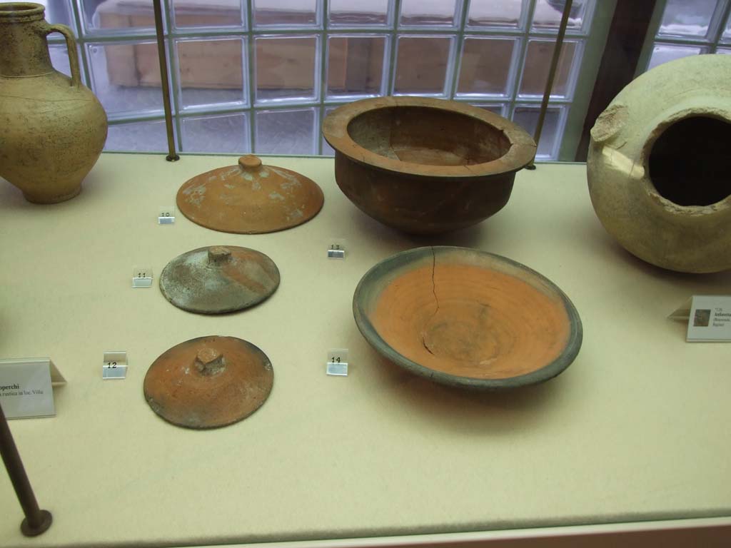 Finds from Villa Regina Boscoreale. December 2006. Now in Boscoreale Antiquarium.
Left are Terracotta covers from storeroom XII.
Right front is a ceramic plate with black rim from room II.
Behind is a terracotta cooking pot (pentola) from room II.