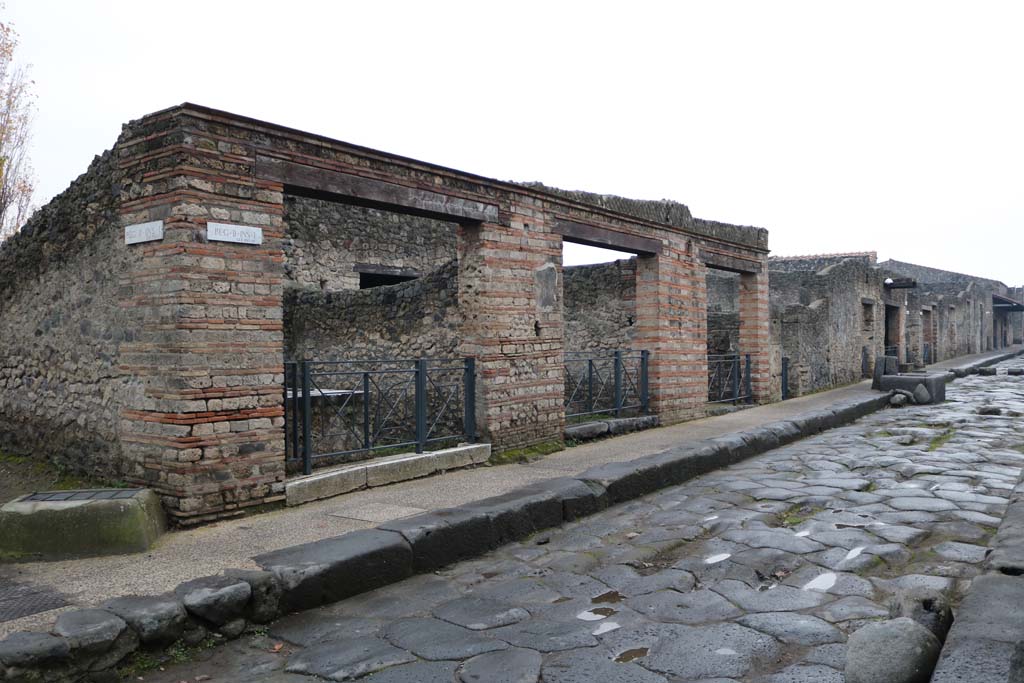 Via dell’Abbondanza, south side. December 2018. 
Looking west from II.1.6 towards II.1.1 at rear of fountain. Photo courtesy of Aude Durand.
