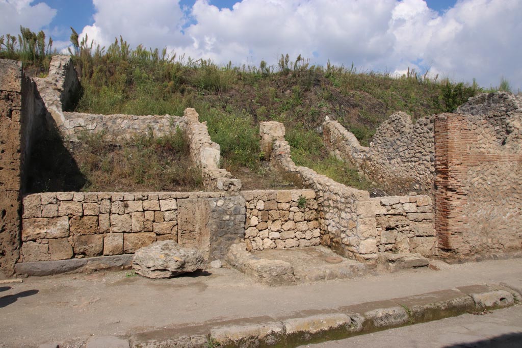Via dell’Abbondanza, north side. October 2022. 
Looking north to newly “cleaned” entrance and corridor into the unexcavated Casa di M. Satrius, III.6.4, in centre.
On the left is the shop at III.6.3. Photo courtesy of Klaus Heese
