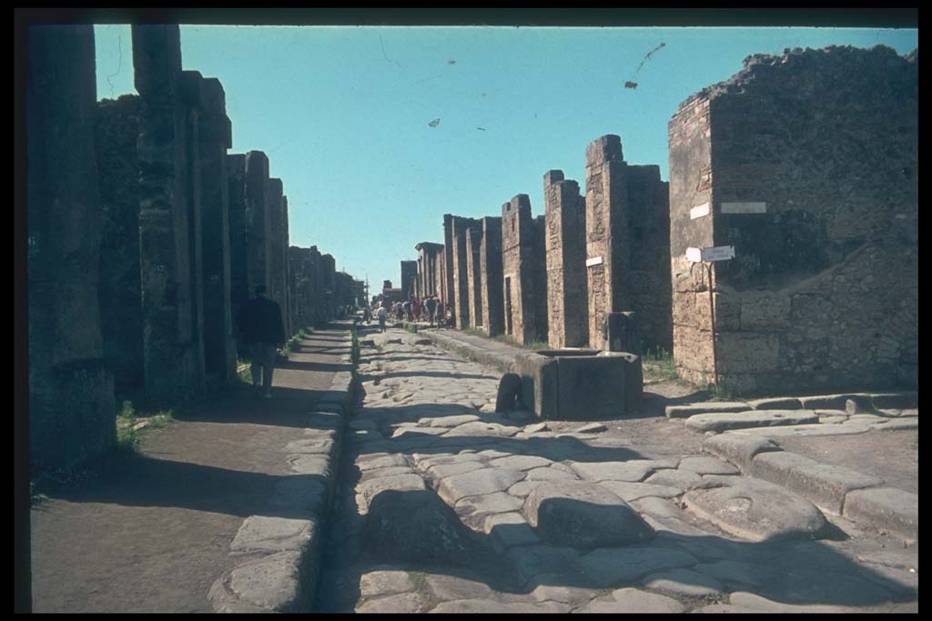 Via della Fortuna between VII.4 and VI.13. Looking west towards fountain and junction with Vicolo dei Vettii, on right.
Photographed 1970-79 by Günther Einhorn, picture courtesy of his son Ralf Einhorn.