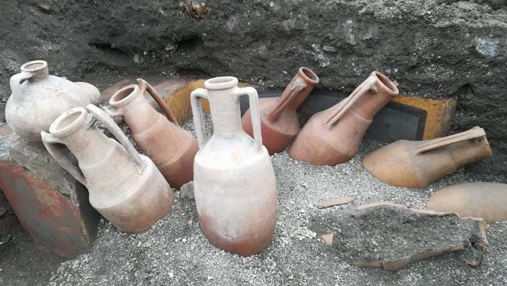 V.3 Pompeii. March 2019. Thermopolium at the crossroads between Vicolo delle Nozze d’Argento and Vicolo dei Balconi.
The discovery of amphorae located in front of the counter at the moment of excavation reflected the painted image on the counter exactly.
V.3 Pompei. Marzo 2019. Thermopolium all'incrocio tra Vicolo delle Nozze d'Argento e Vicolo dei Balconi.
La scoperta di anfore situate di fronte al bancone al momento dello scavo rifletteva esattamente l'immagine dipinta sul bancone.
Photograph © of Parco Archeologico di Pompei.