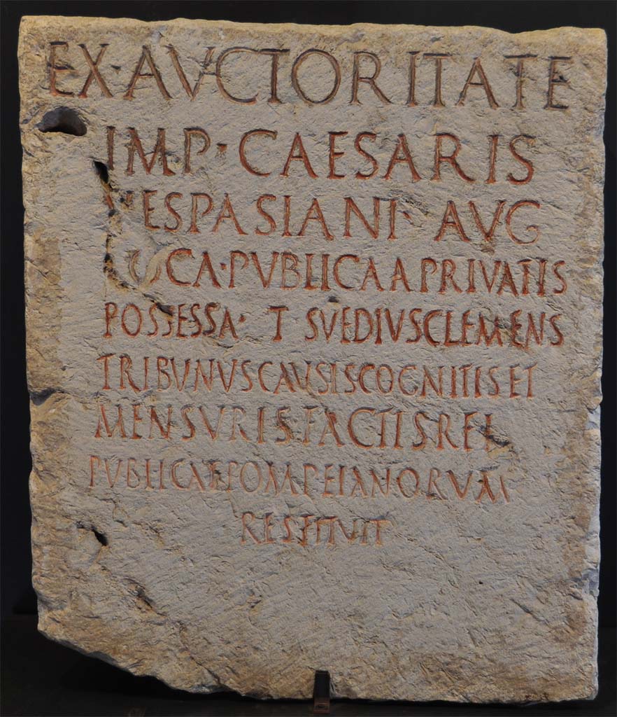 HGW05 Pompeii. Cippus of Suedius Clemens. Found 16th August 1763.
Found on the south of the street close to the entrance to HGW05, almost opposite to the circular seat of Mamia.
Now in Naples Archaeological Museum. Inventory number 3848.
Photo � Livius.org Use subject to  Creative Commons Attribution-ShareAlike 3.0

The inscription reads
EX AVCTORITATE
IMP CAESARIS
VESPASIANI AVG 
LOCA PVBLICA A PRIVATIS
POSSESSA T SVEDIVS CLEMENS
TRIBVNVS CAVSIS COGNITIS ET
MENSVRIS FACTIS REI
PVBLICAE POMPEIANORVM
RESTITVIT      [CIL X 1018]

According to Epigraphik-Datenbank Clauss/Slaby (See www.manfredclauss.de) this reads

Ex auctoritate
Imp(eratoris) Caesaris
Vespasiani Aug(usti)
loca publica a privatis
possessa T(itus) Suedius Clemens
tribunus causis cognitis et
mensuris factis rei
publicae Pompeianorum
restituit      [CIL X 1018]

By virtue of authority conferred upon him by the Emperor Vespasian Caesar Augustus, 
Titus Suedius Clemens, tribune, having investigated the facts and taken measurements,
restored to the citizens of Pompeii public places illegally appropriated by private persons.

Similar Cippi were found at the Porta Marina, Porta Nocera and the Porta Vesuvio.
The wording �rei publicae Pompeianorum� on this one, discovered in 1763, was the first positive identification that the site was Pompeii. 
Until then scholars had divided opinions on the city buried under Civita. Many, including the first official excavators, thought it was the ancient city of Stabiae.
See Conticello, B., Ed, 1990. Rediscovering Pompeii. Rome: L�Erma di Bretschneider. (p. 225).
