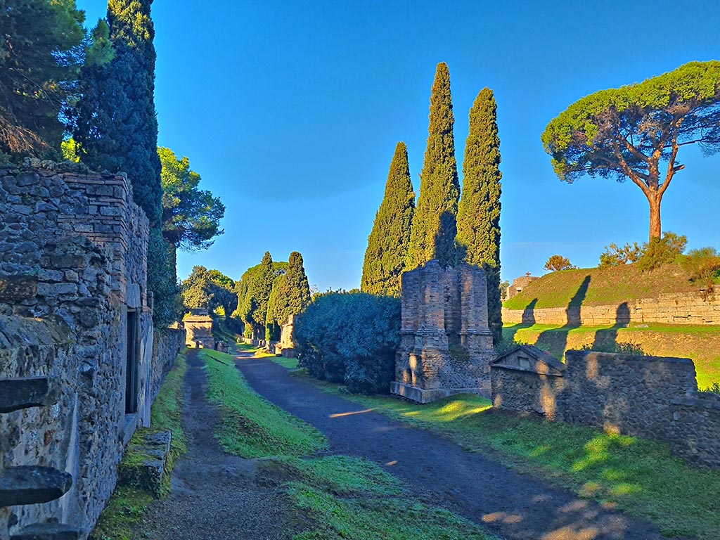 Via delle Tombe, looking west, Pompeii. October 2024.
Tomb 7ES, with steps built into front wall, on left. Photo courtesy of Giuseppe Ciaramella.