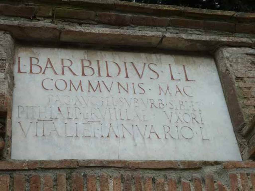 Pompeii Porta Nocera. May 2010. Tomb 15ES. Marble plaque with Latin inscription:
L BARBIDIVS L(uci) L(ibertus)
COMMVNIS MAG(ister)
PAG(i) AVG(usti) FEL(icis) SVBVRB(ani) SIBI ET
PITHIAE P(ubli) L(ibertae) RVFILLAE VXORI
VITALI ET IANVARIO L(iberis).
Lucius Barbidius Communis was a freedman of Lucius Barbidius and a magistrate/priest of the Pagus Augustus Felix Suburbanus.
He constructed the tomb for himself, his wife Pithia Rufilla freedwoman of Publius Pithius, and their two sons Vitalis and Ianuarius.