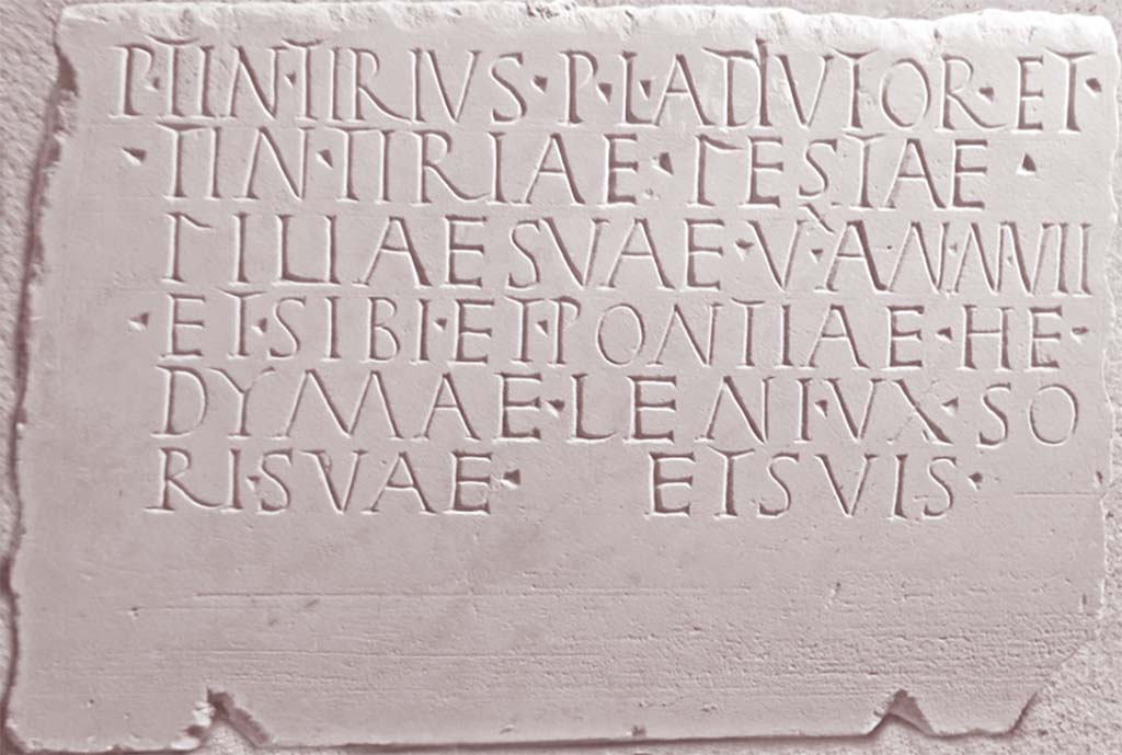 Pompeii Tower I or Tower II (*see note below). 
Marble sepulchral tablet found during the removal of the eruptive material in the chamber (June 4, 1952).
This records the names of Publius Tintirius, his daughter Tintiriae Festae, and his wife Pontiae Hedymaeleni. 
Now in PAP deposit, inventory number 17130.
According to the Epigraphic Database Roma this reads
P(ublius) Tintirius P(ubli) l(ibertus) Ad`i´utor et
Tintiriae Festae,
filiae suae - v(i)`x´(it) an(nis) VII -,
et sibi et Pontiae He=
dymaeleni, uxso= 
ri suae, et suis.   [EDR171965]

According to Van der Graaf, an “aggressive” translation may read as follows  –

Publius Tintirius Audiutor, son of Publius [made this] 
for his daughter Tintiria…….esta [beginning of name apparently lost] (she lived
  7 years)
and for himself
and Pontia Hedyma, his gentle wife
and their [family?]

(* NOTE: Excavation notebooks report the discovery of an epitaph in the main chamber of the tower in the 1950’s. …….
The notebook tells us its dimensions, 42 x 28 x 4.5 centimetres.)
Van der Graaf’s note no.54 reads –
“Excavation diary entry June 4, 1952. The excavation reports are vague, describing the recovery of the epitaph in what the excavators designate Tower I. Assuming continuity in excavation nomenclature, this associates the report with Tower II since Maiuri later describes the tower as I: see Maiuri 1959, 82-83.”)
(NOTE 55: “With thanks to Professor A. Riggsby for his invaluable translation of the text”.)

See Van der Graaf, I. (2018). The Fortifications of Pompeii and Ancient Italy. Routledge, (p.154) & Notes 54 and 55 on p.171.


