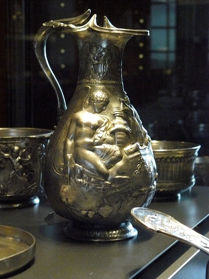 Villa della Pisanella, Boscoreale. Oenocho� of the treasure of Boscoreale - Silver wine vase with repousse decorations, traces of gilding, late 1st century AD - Height about 25 cm. Side 1.
On the collar a winged genius gives water to a griffin. On the body one of two Victories sacrificing a bull on either side of an altar bearing the palladium.

Oenocho� du tr�sor de Boscoreale - Vase � vin en argent d�cors repouss�, traces de dorure, fin du Ier si�cle ap. J.C. - Hauteur environ 25 cm. C�t� 1.
Sur le col un g�nie ail� abreuvant un griffon. Sur la panse l�un des deux Victoires sacrifiant un taureau de part et d'autre d'un autel portant le palladion.

Now in the Louvre, Inventory number BJ 1899.
