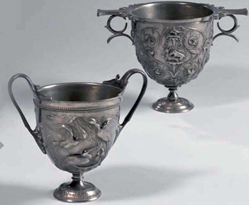 Villa della Pisanella, Boscoreale. At the back is the reverse side of the silver Cantharus decorated with floral scrolls and animal fights.
A l'arri�re se trouve l'inverse du Cantharus argent� � d�cor de rinceaux floraux et combats d'animaux.
Now in the Louvre, inventory number BJ1907.
Voir/See De Villefosse H., 1899. L'argenterie et bijoux d'or du tr�sor de Boscoreale description des pi�ces conserv�es au Mus�e du Louvre: Monuments et Memories 5 1899 with supplement 1902, pl. X.

At the front is one of a pair of cantharus, with scenes with storks.
Two scenes unfold around the storks' nest: the parents bring prey back to their young and are challenged by an intruder
� l'avant est l'un d'une paire de cantharus, avec des sc�nes avec des cigognes.
Deux tableaux se d�roulent autour du nid des cigognes : les parents rapportent � leurs petits des proies qui leur sont disput�es par un intrus
Now in the Louvre, inventory number BJ1904.
Voir/See De Villefosse H., 1899. L'argenterie et bijoux d'or du tr�sor de Boscoreale description des pi�ces conserv�es au Mus�e du Louvre: Monuments et Memories 5 1899 with supplement 1902, pl. XIII.
