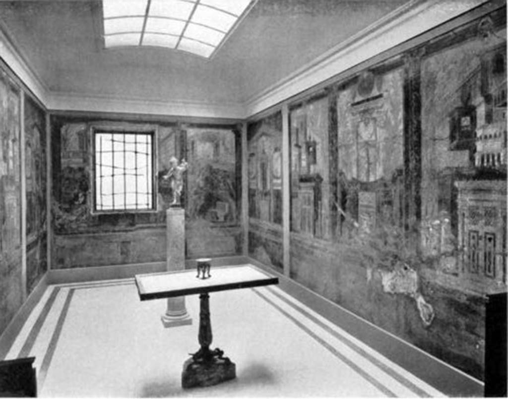 Villa of P. Fannius Synistor at Boscoreale. Cubiculum M and alcove, 1910. As displayed with frescoes and mosaic floor after the relocation of the room within the gallery. The new arrangement introduced light through the window and from a skylight in the ceiling. Note the plain mosaic floor. The table in the centre and the bronze figure �Running Eros, Holding a Torch� are said to be from �a villa in Boscoreale�. The bronze figure �Running Eros, Holding a Torch� is now in the Pierpoint Morgan Library in New York City. The marble table had a bronze rim decorated with a beautiful design inlaid with silver and niello. It was found in pieces and was put together with some restorations, especially in the leg. 