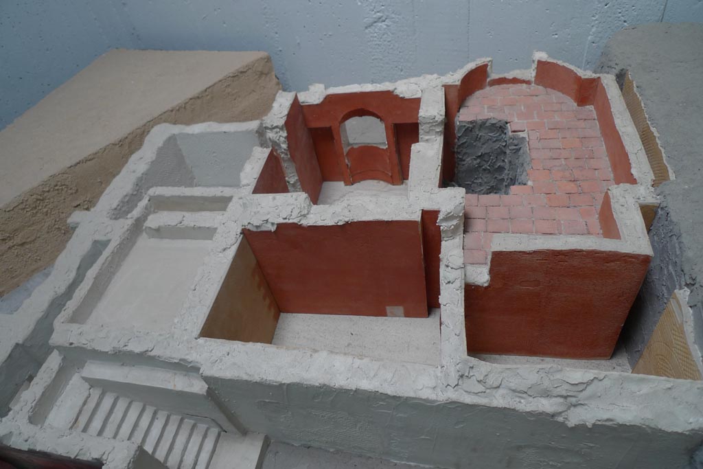 Complesso dei triclini in località Moregine a Pompei. July 2010. Baths suite looking north on December 2000 model.
Photo courtesy of Michael Binns.
Left to right are steps G, 8, 7 (front), service areas 9, 10, N and 2 (behind) and apodyterium S, tepidarium O and caldarium 3 (at rear).
The building was reoccupied immediately after the eruption of 79 A.D.
Evident traces are the tiled floors made over the volcanic earth in rooms 3 and O.
See De Simone, A., 2000. L’indagine archeologica in località Murecine a Pompei, in A. De Simone e S. C. Nappo (a cura di), Mitis Sarni Opes, Napoli, 2000, p. 75