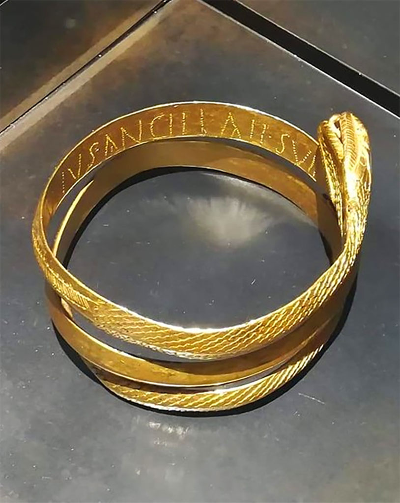 L’edificio B di Murecine a Pompei. Unit D, room 8, gold and glass paste bracelet in the form of a snake.
The bracelet has an inscription DOMINUS ANCILLAE SUAE (master to his slave girl). PAP inventory number 81580.