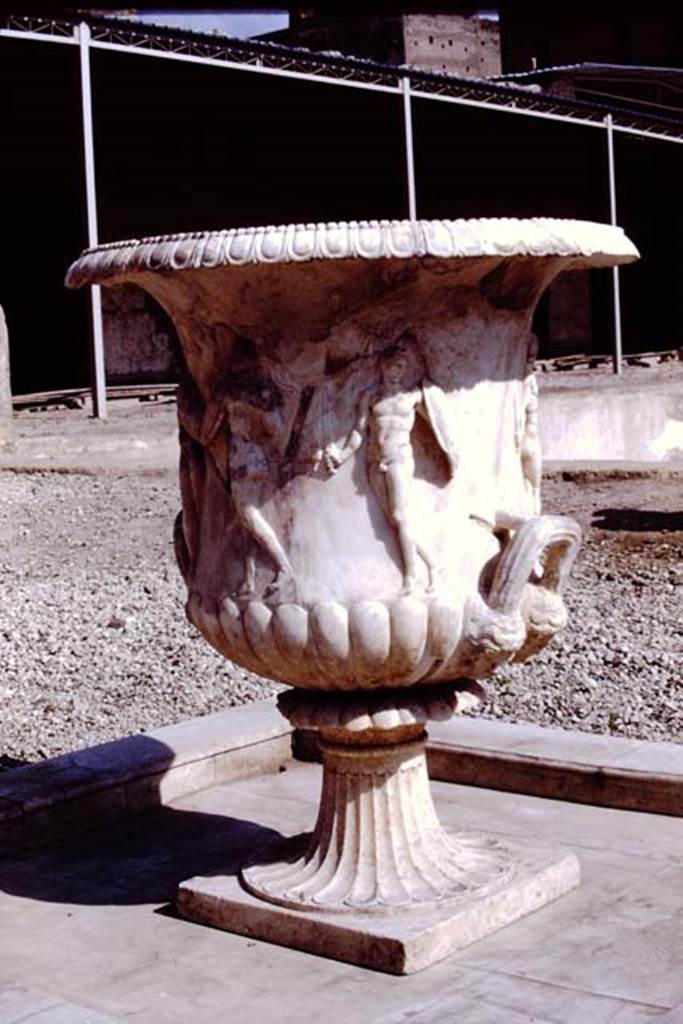 Oplontis Villa of Poppea, 1978. Terrace 92. Large crater fountain vase positioned in the centre of the south side of the pool.
Photo by Stanley A. Jashemski.
Source: The Wilhelmina and Stanley A. Jashemski archive in the University of Maryland Library, Special Collections (See collection page) and made available under the Creative Commons Attribution-Non Commercial License v.4. See Licence and use details.
J78f0048
According to Wilhelmina, “We were delighted to see they had discovered the base of the beautiful marble crater fountain in a small pool in the garden area on the south side of the swimming pool where the crater had been originally located. We had admired the fountain on a previous trip, for it had been found earlier, in the rear portico of the villa where it had been stored, possibly after the earthquake.”
See Jashemski, W.F., 2014. Discovering the Gardens of Pompeii: Memoirs of a Garden Archaeologist, (p.263).
According to Wilhelmina, “the base of the large crater fountain was found in fragments in passage 53, where it had been stored at the time of the eruption”.
See Jashemski, W. F., 1993. The Gardens of Pompeii, Volume II: Appendices. New York: Caratzas. (p.298).