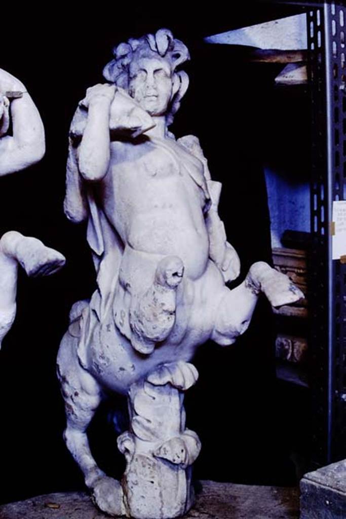 Oplontis Villa of Poppea, 1977. One of a group of four centaurs, a female holding a club and a fawn on her shoulder. 
Two centaur fountains had been on each side of the passageway.
There was no evidence of pipes, so they had not been used as fountains in their final location.
Photo by Stanley A. Jashemski.
SAP{ inventory number 70071.
Source: The Wilhelmina and Stanley A. Jashemski archive in the University of Maryland Library, Special Collections (See collection page) and made available under the Creative Commons Attribution-Non Commercial License v.4. See Licence and use details.
J77f0339
According to De Caro, a group of four centaurs were found under portico 33 on 17th February 1970. 
When they were found, they were very badly damaged. Heads and limbs were mostly detached and it was necessary to provide patient and pain-staking work of re-composition. 
See De Caro, S.1976. Sculture dalla villa �di Poppea� in Oplontis (p.198) in Cronache Pompeiane, II, 1976, (p.184-225)
