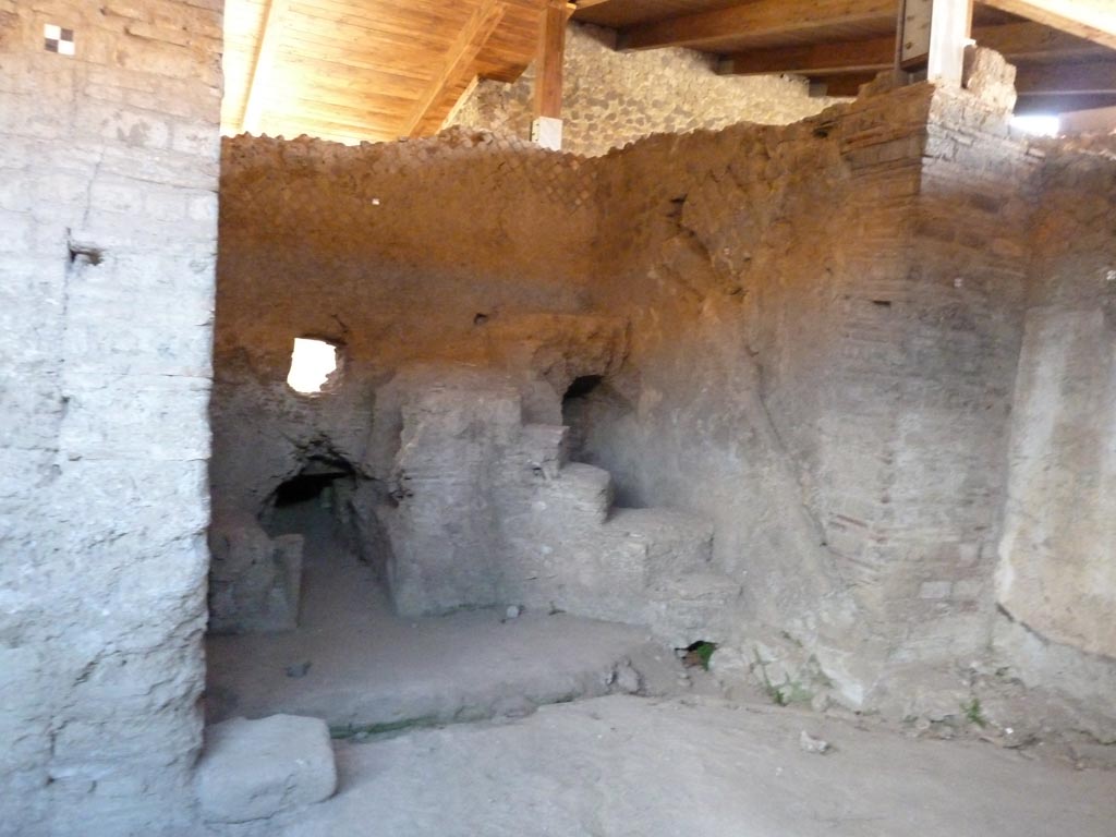 Stabiae, Villa Arianna, September 2015. Room 28, looking west across room giving access to room 29, praefurnium or boiler room.
According to the description board, a few steps to a podium on the western side gave access to the place where a bronze cauldron heating the nearby caldarium stood.
